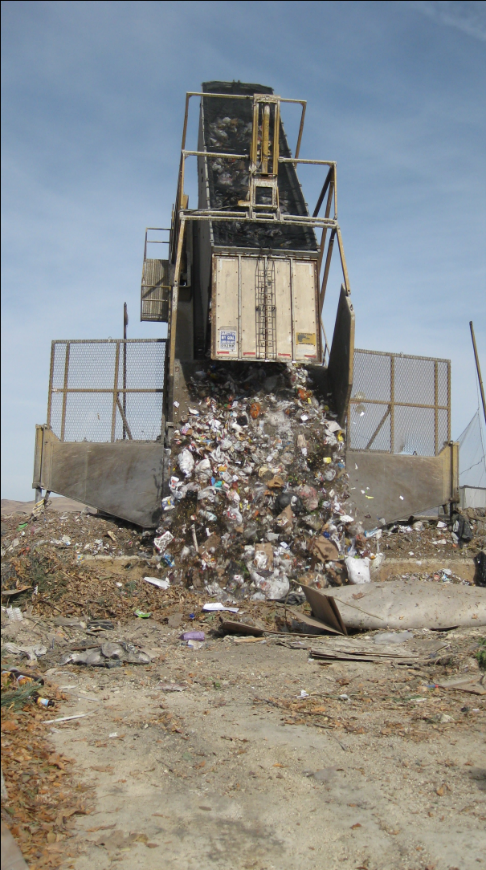 Large tipper machine pours trash into Lockwood landfill.